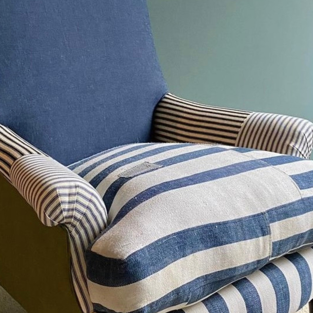 Blue and off-white colour striped chair. The back of the chair is a solid navy blue colour. The chair is facing the camera at an angle.