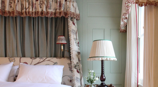  Close up view of a bright bedroom with a lovely textured headboard and bed